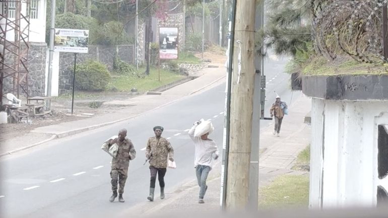 Des hommes armés et des civils marchant dans une rue de Goma, portant "leurs affaires", le 27 janvier 2025. © AFP - AFPTV